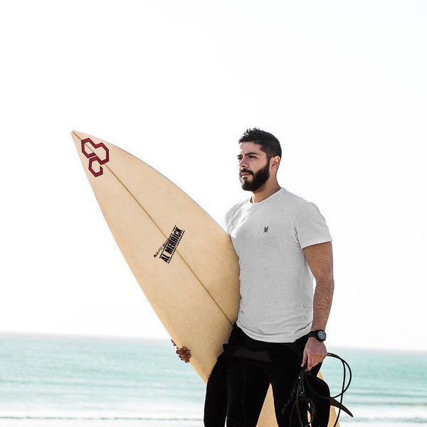 person walking with surfboard